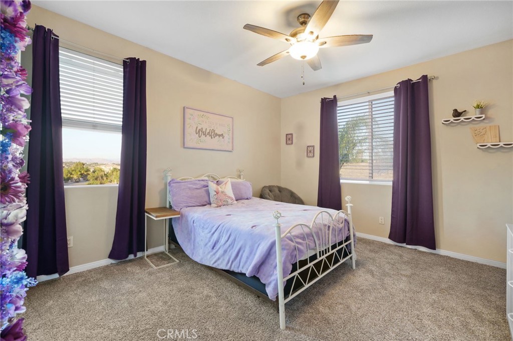 18604 Sunset Knoll Drive Riverside, CA 92504 - Photo 40 of 66 a spacious bedroom with a bed and a chandelier