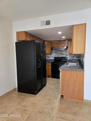 a kitchen with stainless steel appliances granite countertop a refrigerator and a stove