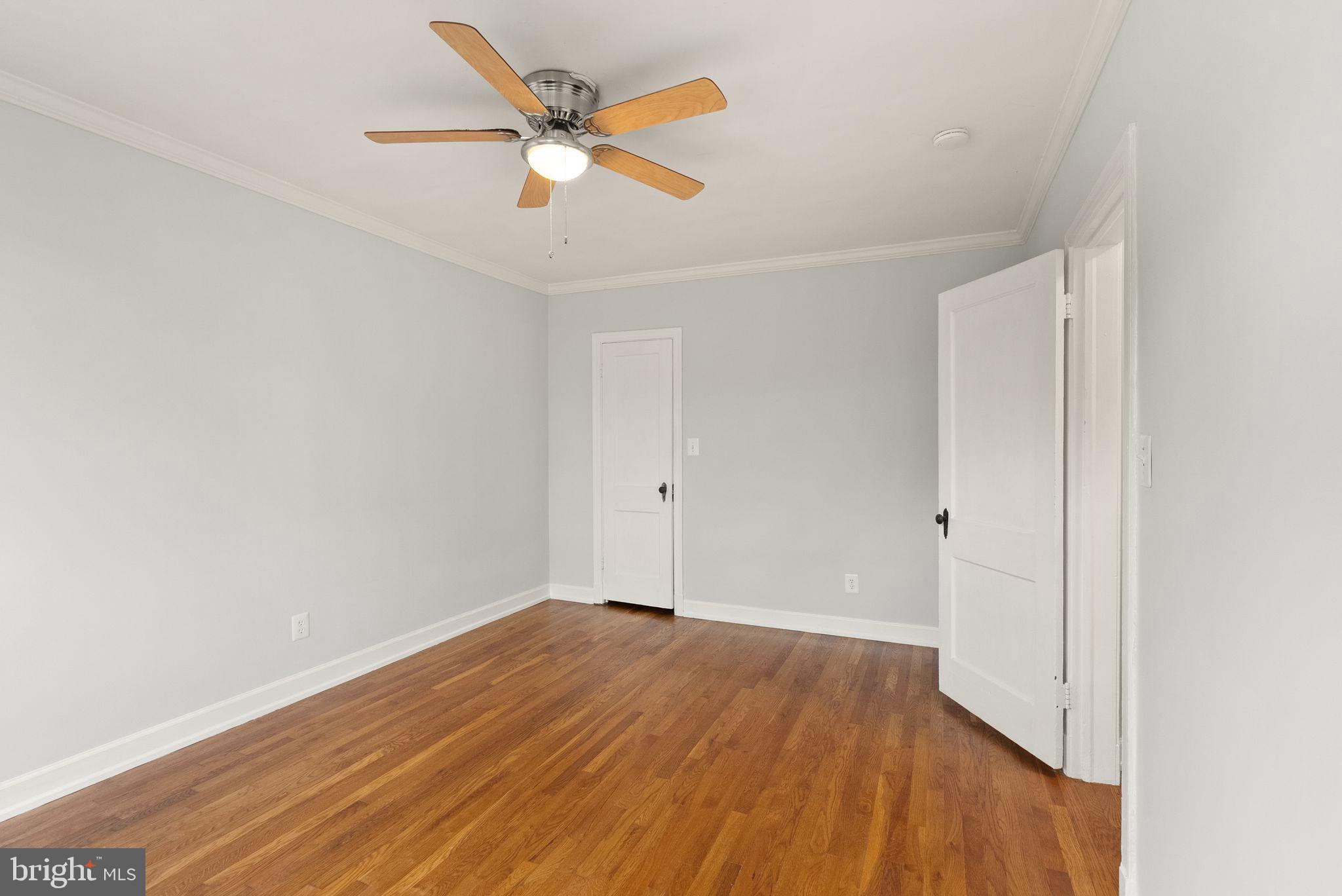939 Longfellow Street Northwest, Unit 305 Washington, DC 20011 - Photo 12 of 17 an empty room with wooden floor and a ceiling fan