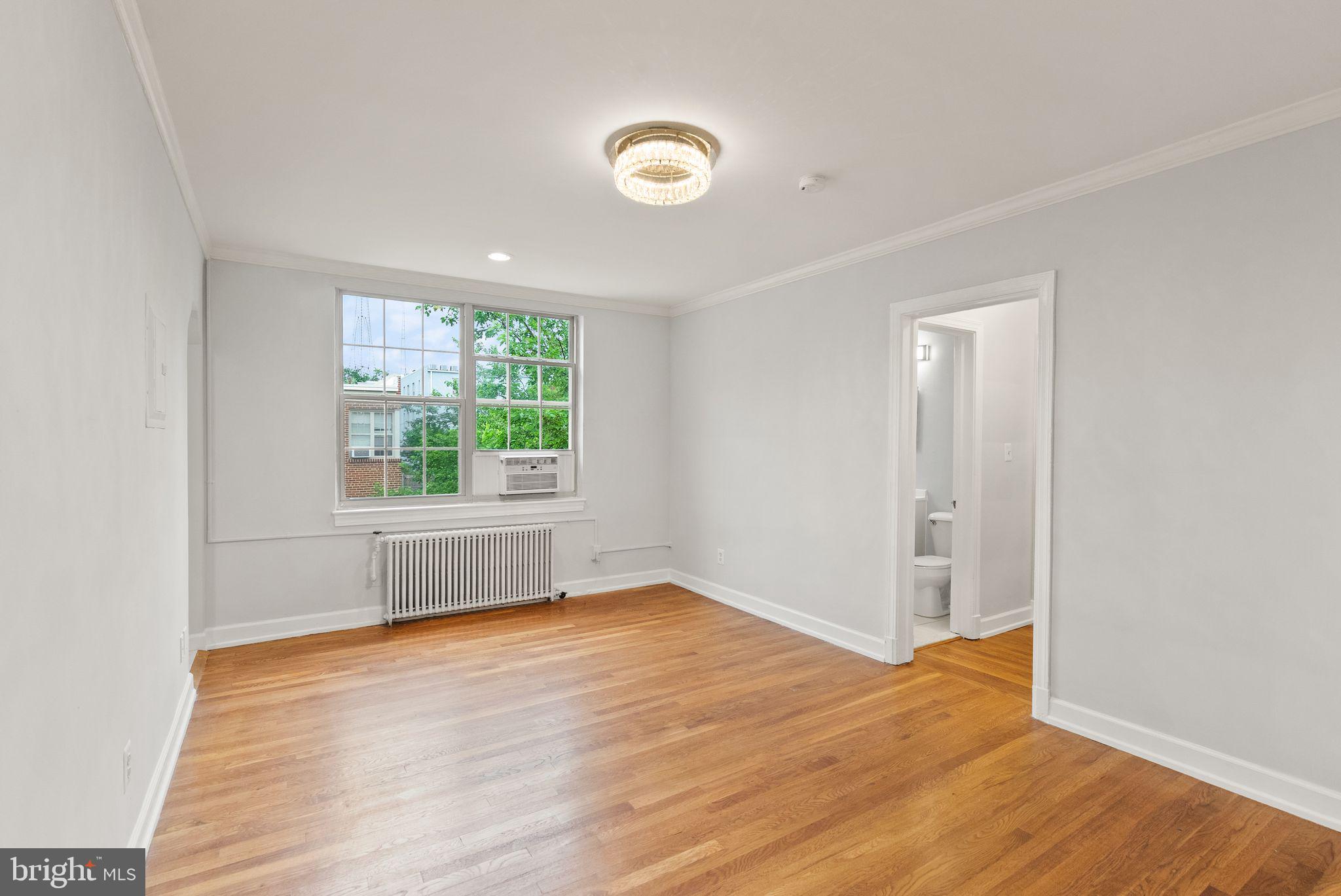 939 Longfellow Street Northwest, Unit 305 Washington, DC 20011 - Photo 2 of 17 an empty room with wooden floor and windows