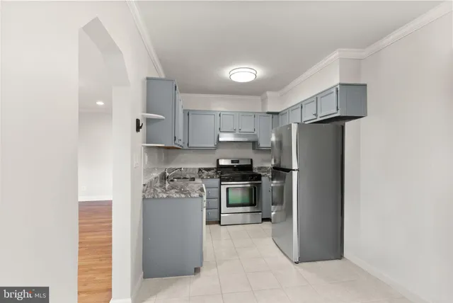 a kitchen with stainless steel appliances granite countertop a refrigerator stove and oven