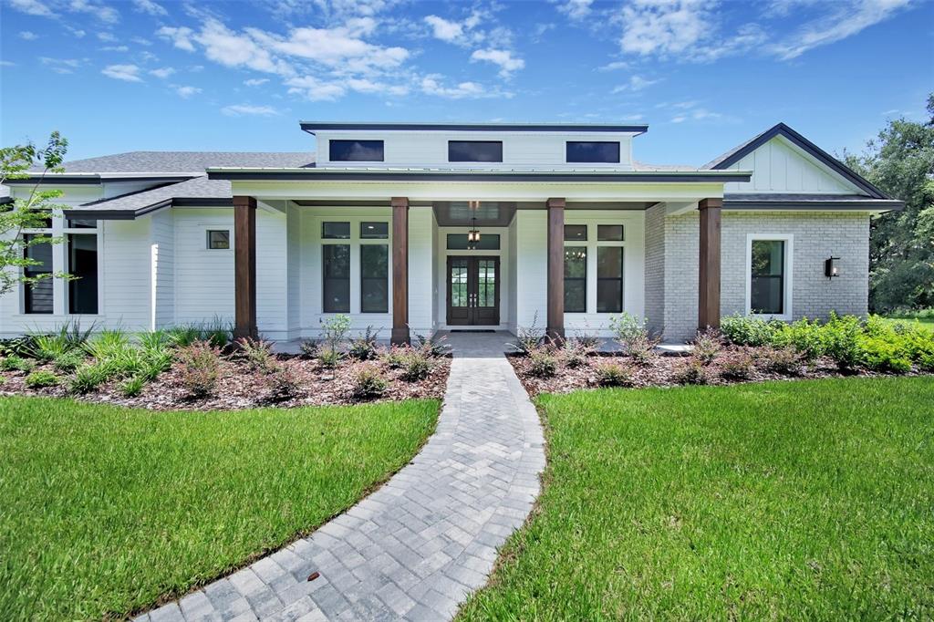 a front view of a house with a garden and plants