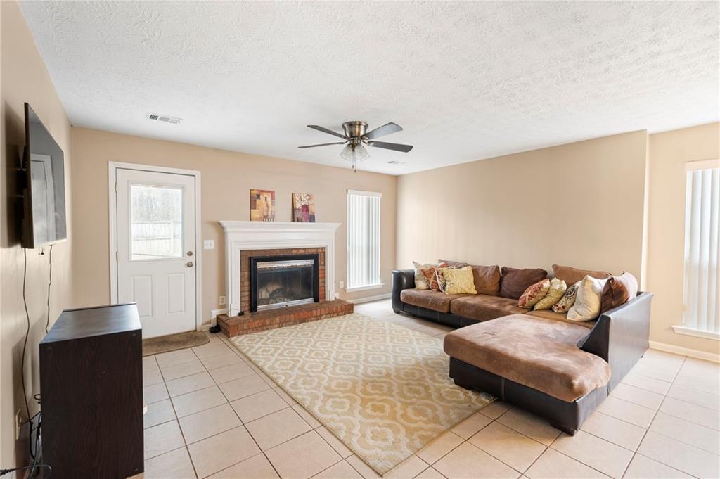 905 Ahearn Court Suwanee, GA 30024 - Photo 13 of 26 a living room with furniture and a fireplace