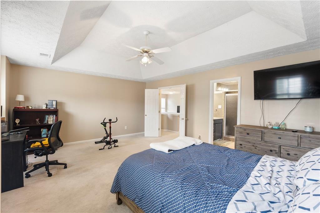 905 Ahearn Court Suwanee, GA 30024 - Photo 17 of 26 a bedroom with a bed a flat screen tv and dresser