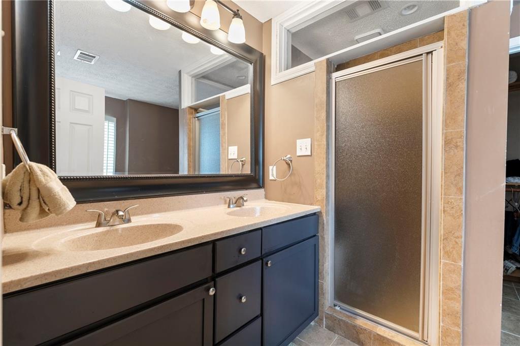 905 Ahearn Court Suwanee, GA 30024 - Photo 19 of 26 a bathroom with a double vanity sink and a mirror