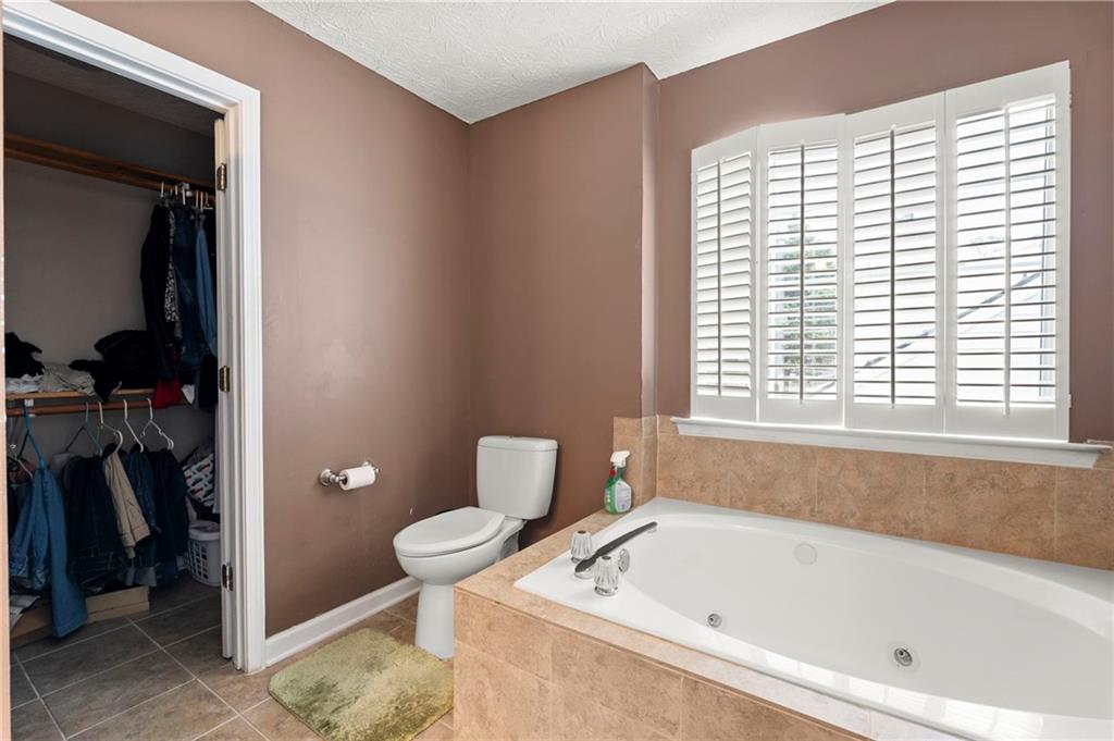 905 Ahearn Court Suwanee, GA 30024 - Photo 20 of 26 a bathroom with a tub and toilet