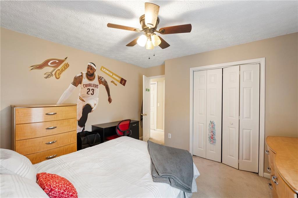 905 Ahearn Court Suwanee, GA 30024 - Photo 22 of 26 a bedroom with a bed and a chandelier