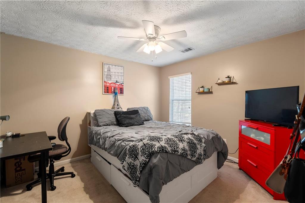 905 Ahearn Court Suwanee, GA 30024 - Photo 24 of 26 a bedroom with a bed and a chandelier