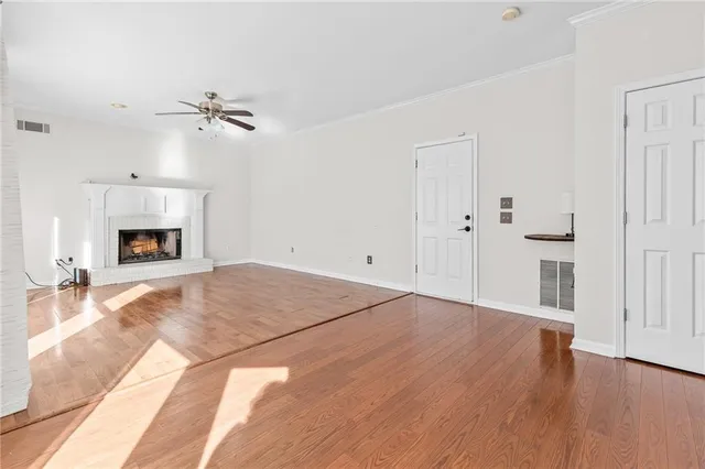 a view of empty room with wooden floor and fireplace