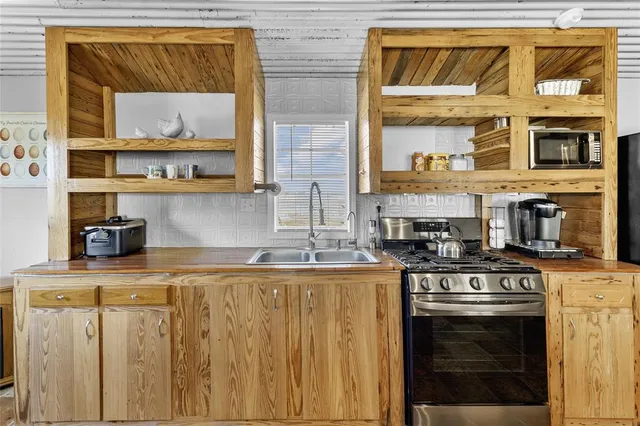 a living room with furniture a stove and a large window