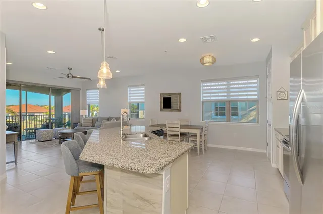 a large white kitchen with a large window and stainless steel appliances
