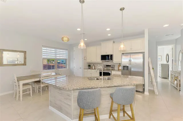 a kitchen with granite countertop a sink a counter top space and living room view