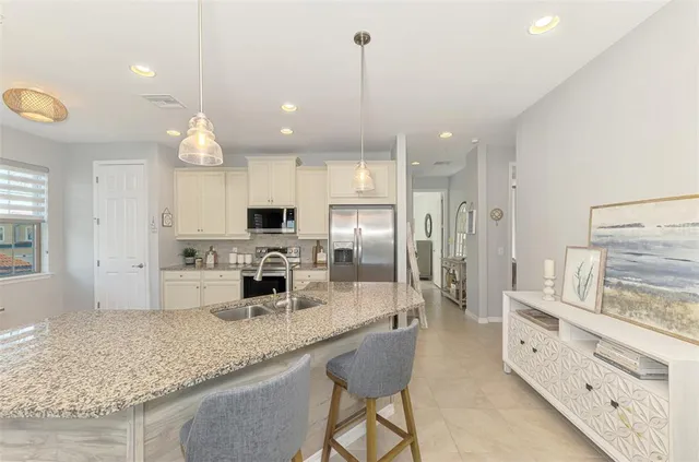 a kitchen with stainless steel appliances granite countertop a refrigerator stove and white cabinets