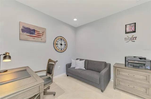a view of a swimming pool with a lawn chairs under palm trees