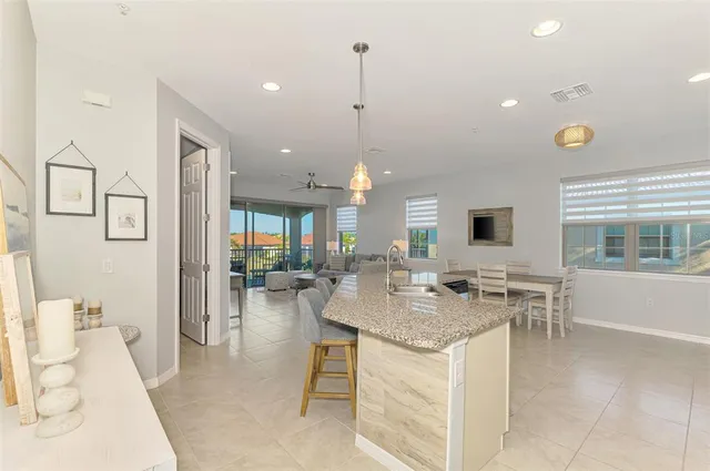 a kitchen with stainless steel appliances kitchen island granite countertop a sink and white cabinets