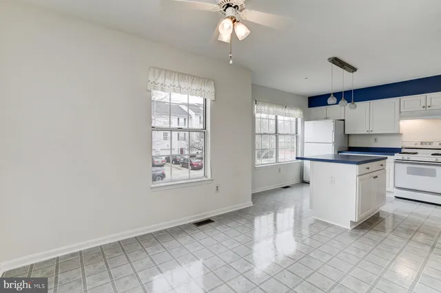 a kitchen with white cabinets and window