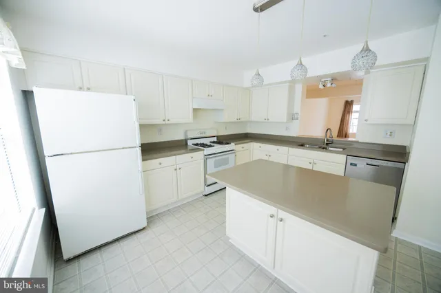 a kitchen with granite countertop white cabinets and white appliances