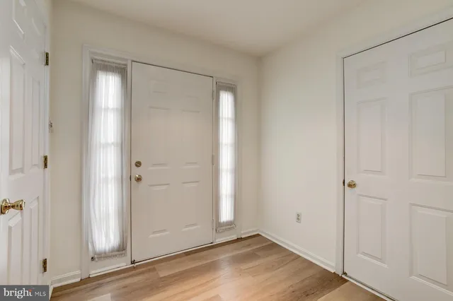 an empty room with wooden floor and closet area