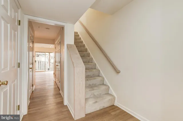 a view of a hallway with wooden floor and entryway