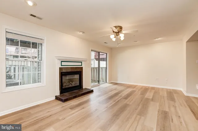 a view of an empty room with a fireplace and a window