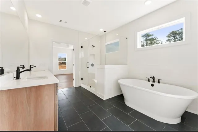 a white bath tub sitting next to a bathroom sink