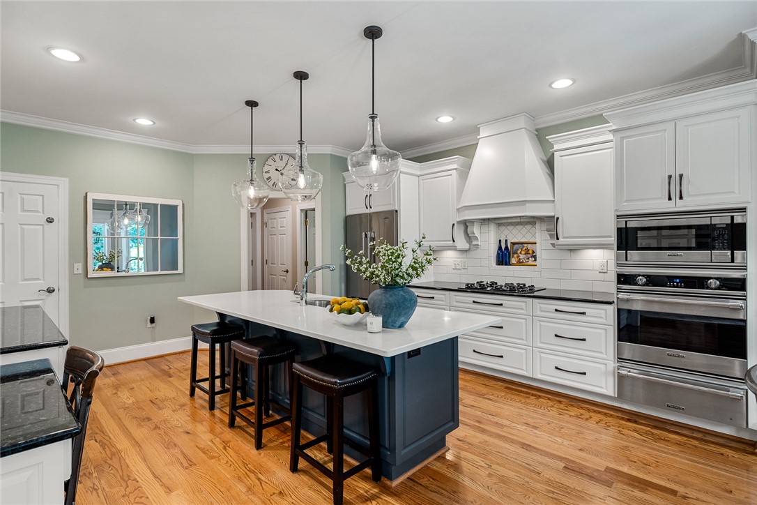 200 Graylyn Drive Anderson, SC 29621 - Photo 11 of 48 Culinary delights await in this bright kitchen with a spacious island, premium appliances, and rich hardwood flooring.