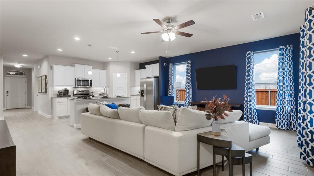 129 Hugo Court Rhome, TX 76078 - Photo 11 of 34 a living room with furniture a flat screen tv and a large window