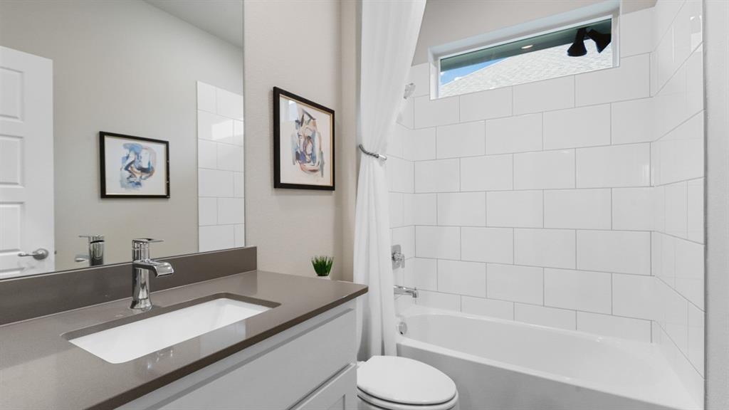 129 Hugo Court Rhome, TX 76078 - Photo 23 of 34 a bathroom with a granite countertop sink a toilet and bathtub