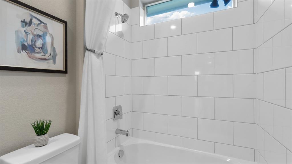 129 Hugo Court Rhome, TX 76078 - Photo 24 of 34 a bathroom with a bathtub and a shower