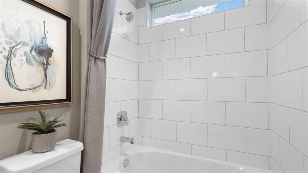 129 Hugo Court Rhome, TX 76078 - Photo 27 of 34 a bathroom with a bathtub shower and a sink