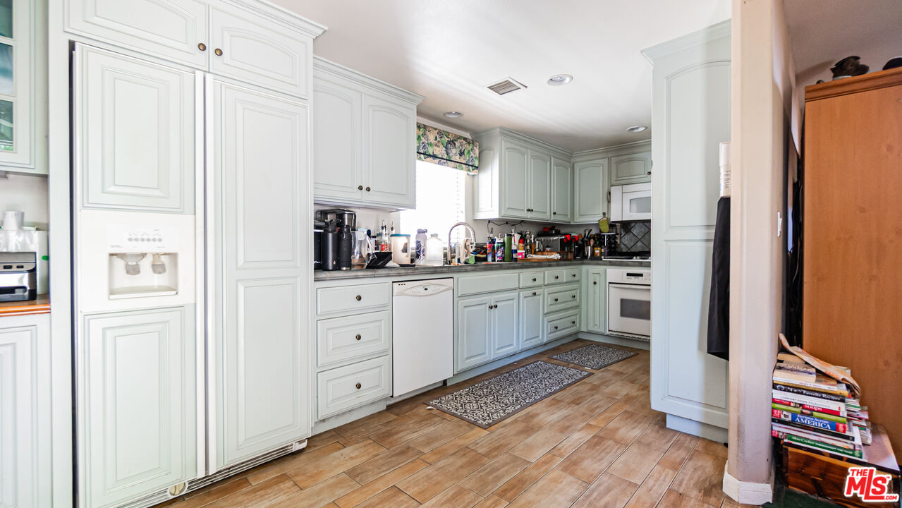 25843 Browning Place Stevenson Ranch, CA 91381 - Photo 12 of 37 a kitchen with white cabinets and white appliances