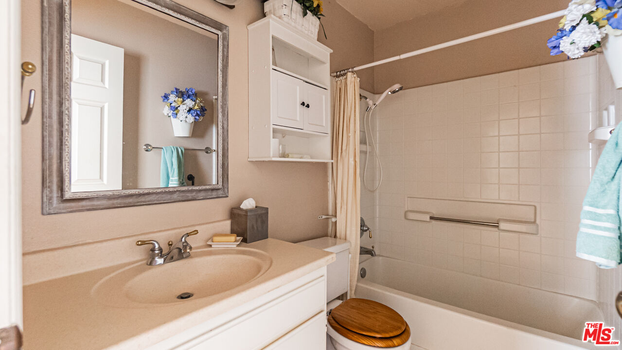 25843 Browning Place Stevenson Ranch, CA 91381 - Photo 19 of 37 a bathroom with a sink a toilet and shower curtain