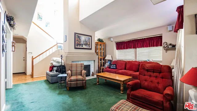 a living room with furniture a red couch and a fireplace