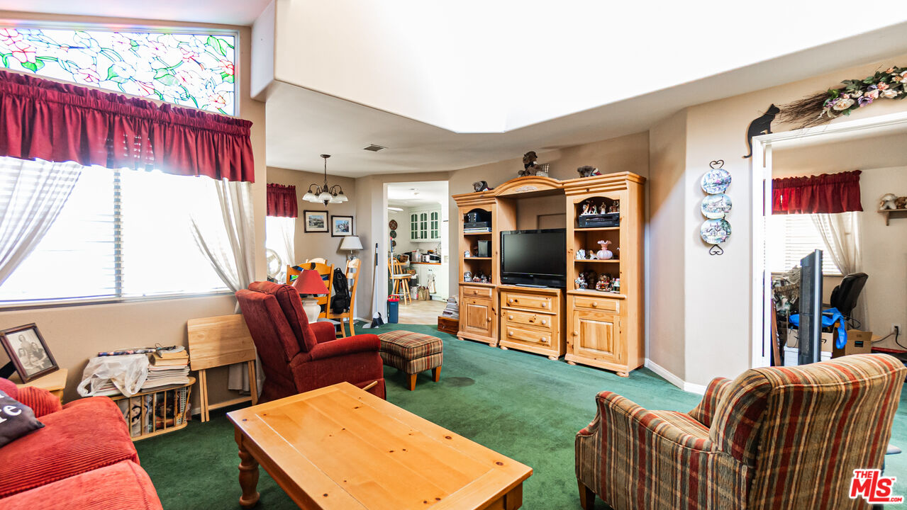 25843 Browning Place Stevenson Ranch, CA 91381 - Photo 8 of 37 a living room with furniture a flat screen tv and a floor to ceiling window