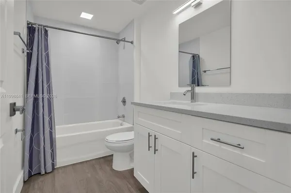 a bathroom with a sink mirror toilet and bathtub