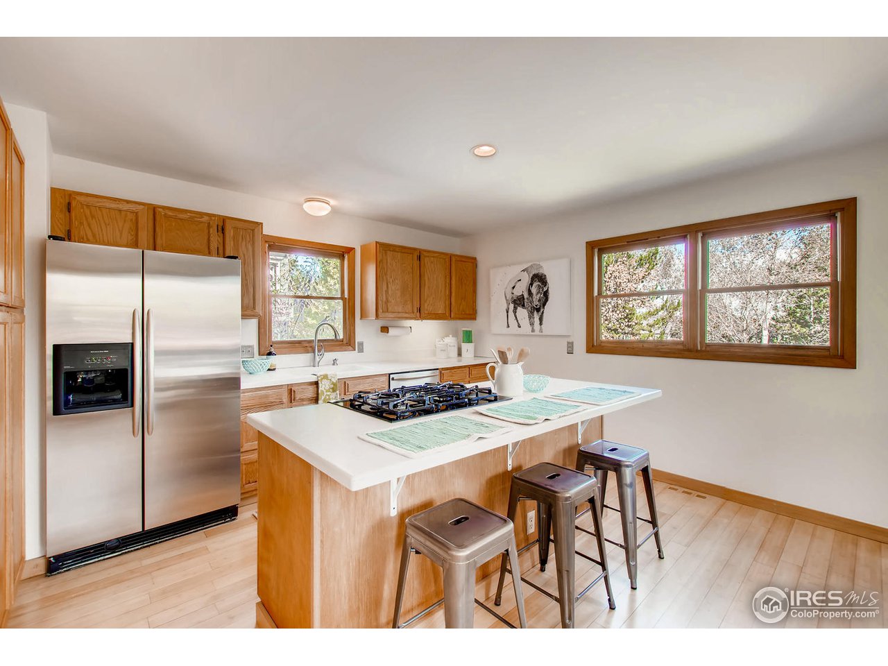 4110 Riverside Avenue Boulder, CO 80304 - Photo 16 of 39 a kitchen with stainless steel appliances granite countertop a stove a refrigerator a microwave a dining table and chairs with wooden floor