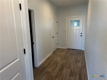 a view of a hallway with wooden floor and closet