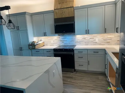 a kitchen with a sink and wooden floor