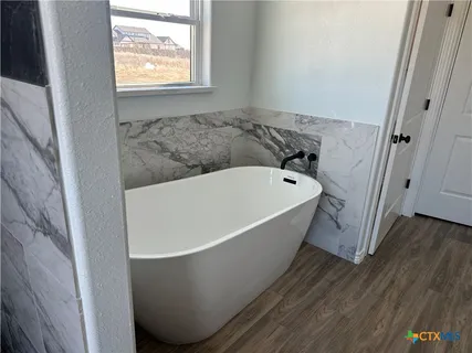 a bathroom with bathtub and window