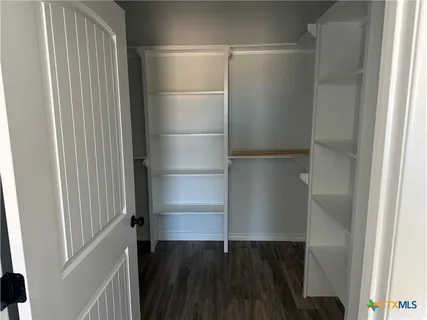 a view of walk in closet with empty racks