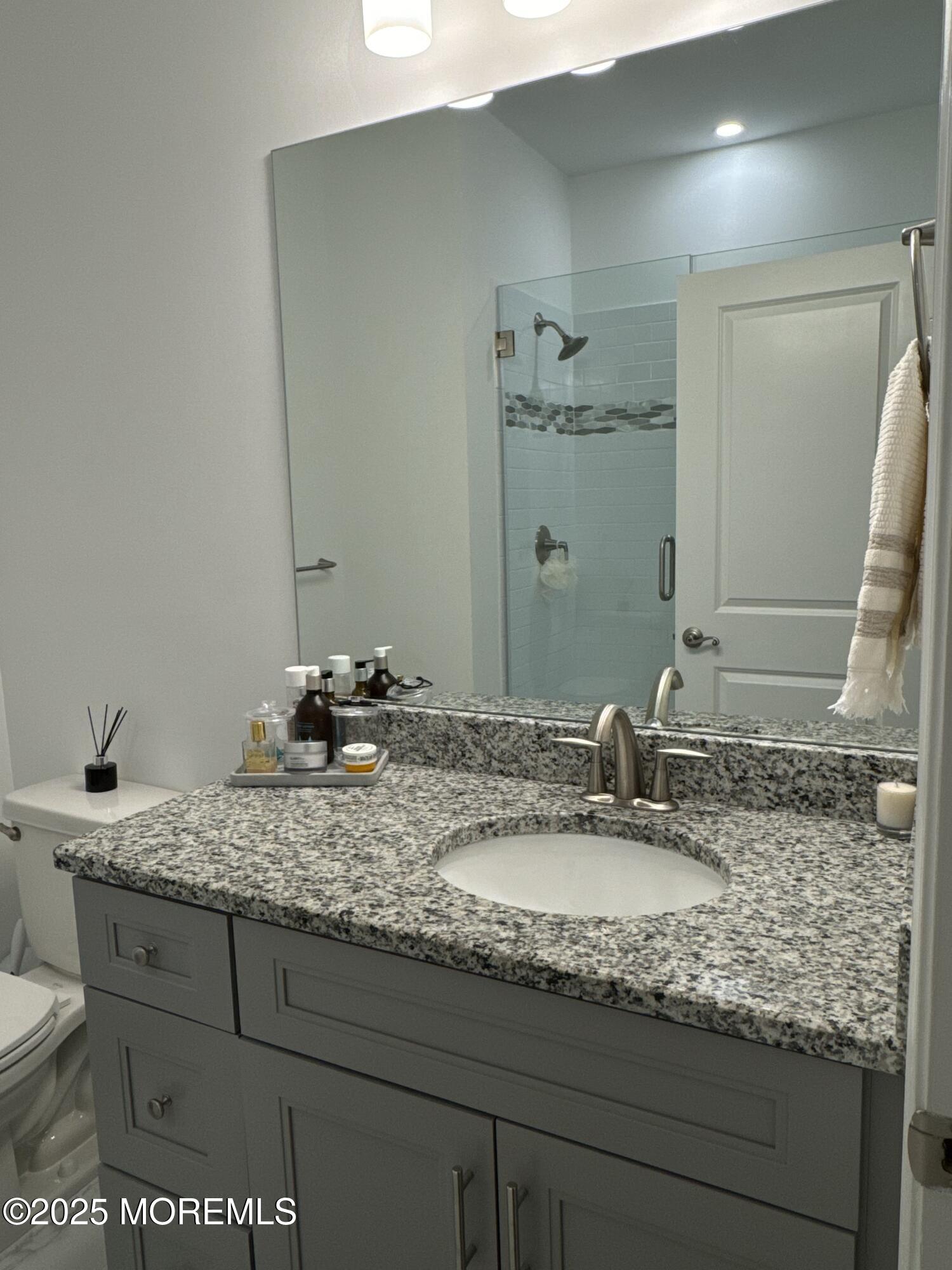 300 Prestige Road Brick, NJ 08723 - Photo 29 of 50 a bathroom with a granite countertop sink and a mirror