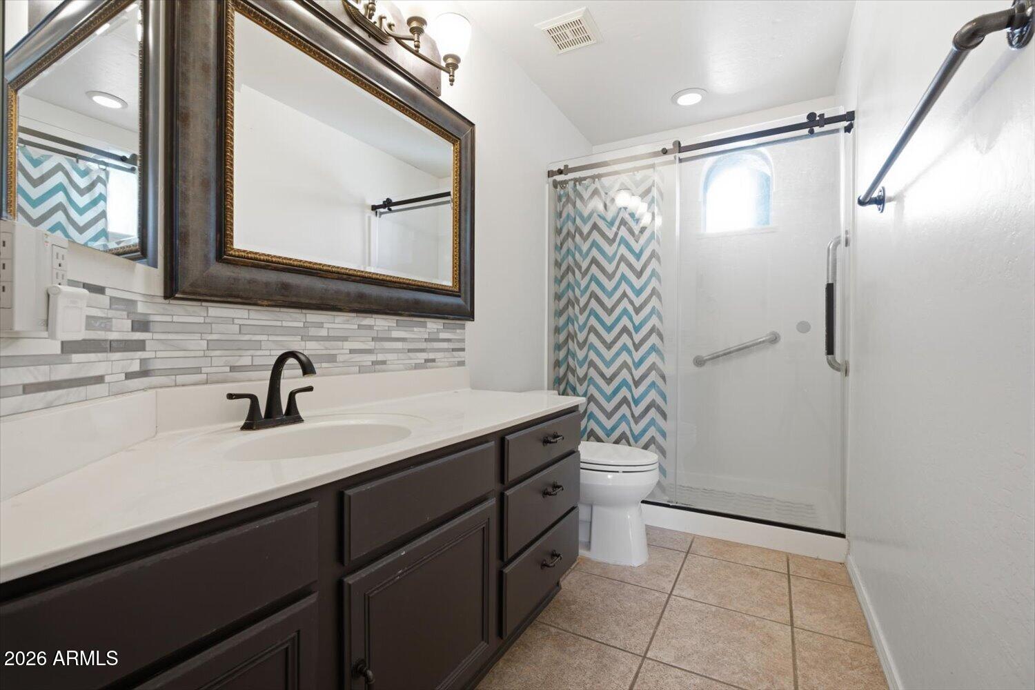 1894 East Mineral Road Gilbert, AZ 85234 - Photo 16 of 48 a bathroom with a granite countertop sink mirror and a shower