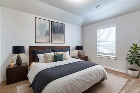 a bedroom with bed and a painting on the wall