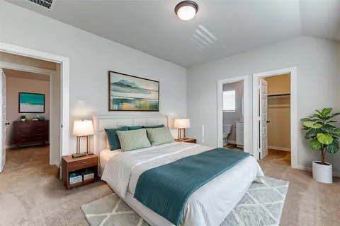 a bedroom with a large bed and a potted plant