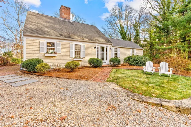 a front view of a house with a yard and potted plants