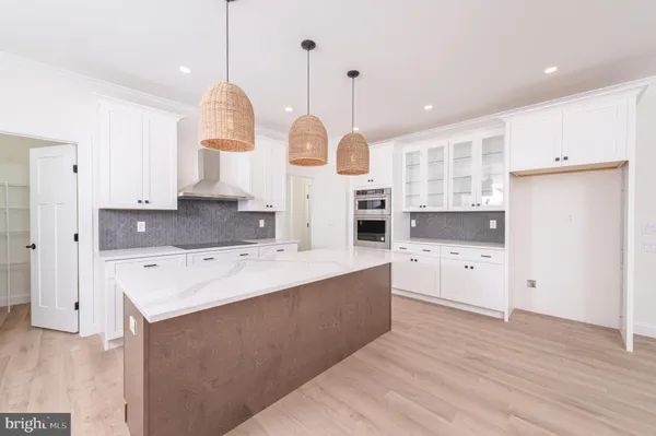 a kitchen with stainless steel appliances granite countertop a sink a stove a refrigerator cabinets and chairs