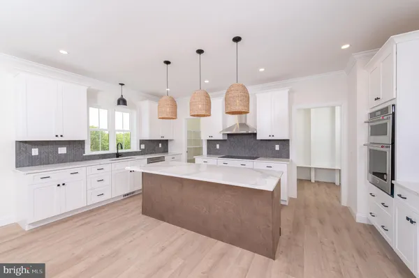 a kitchen with granite countertop a stove a sink a dining table and chairs