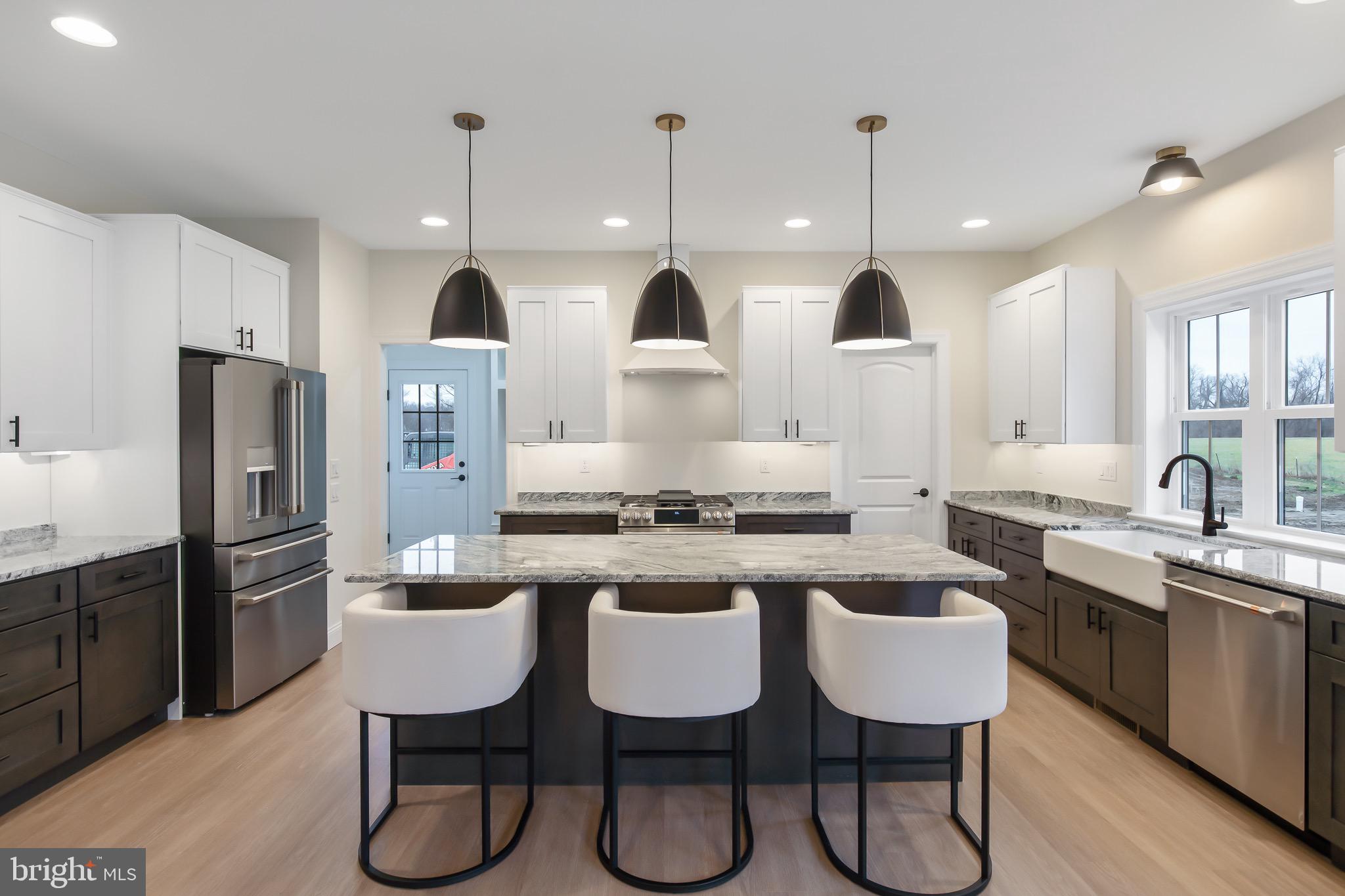 2328 Rockvale Road Lancaster, PA 17602 - Photo 17 of 55 a kitchen with stainless steel appliances granite countertop a sink a stove a refrigerator cabinets and chairs