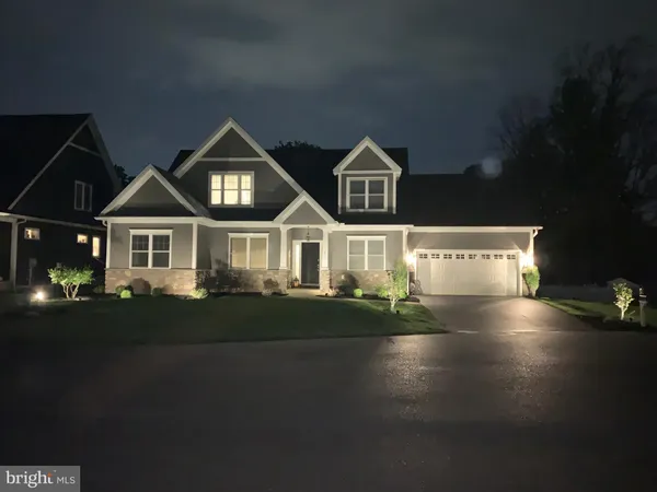 a front view of a house with a yard and green space