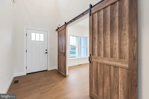 a large kitchen with stainless steel appliances kitchen island granite countertop a table chairs and a wooden floor